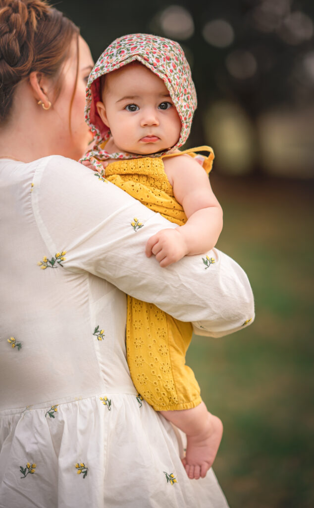 A mom is holding her baby girl at their spring photo session in Newnan, GA. 